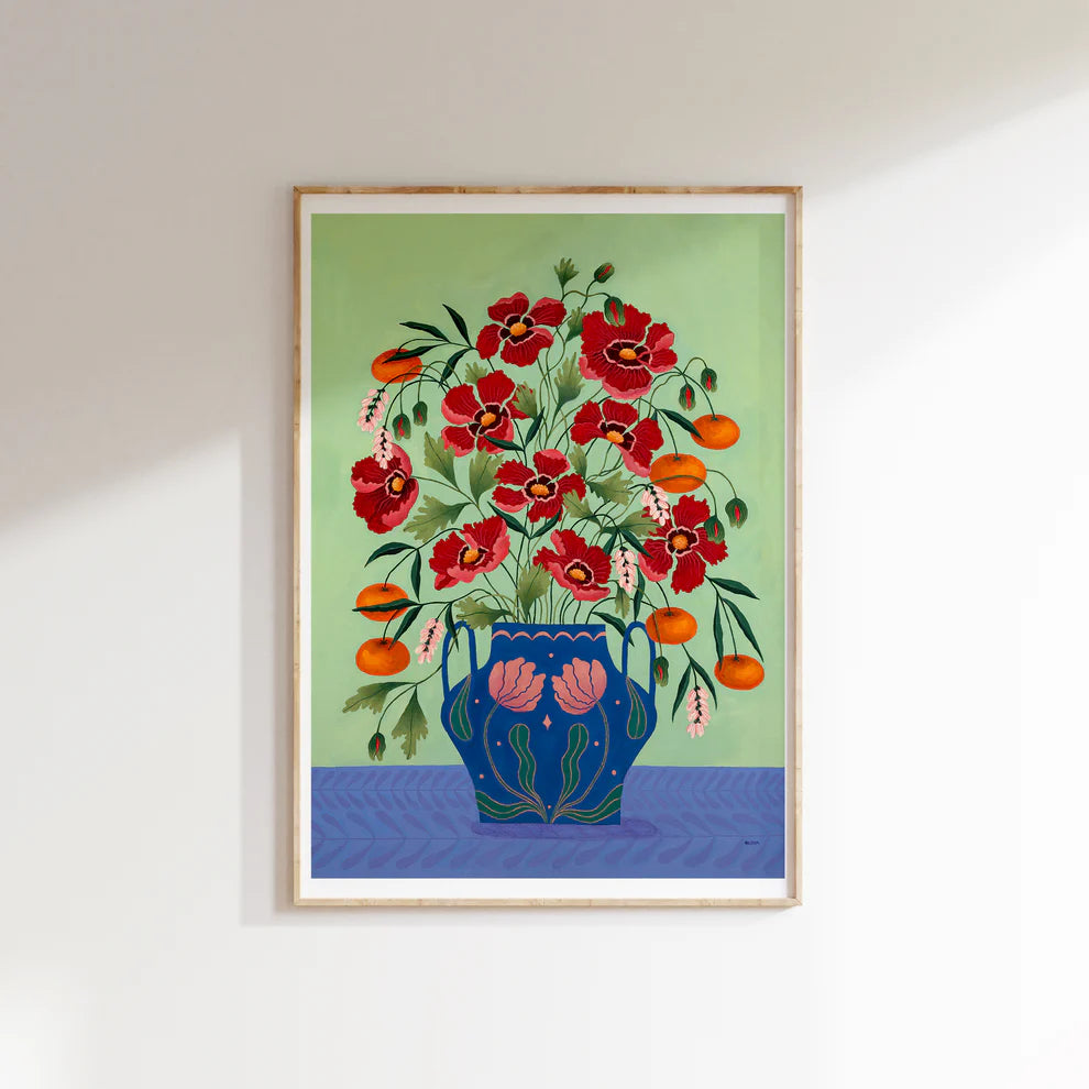 Framed Fine art print of a bright burgundy floral display in a blue vase with light pink floral motif.