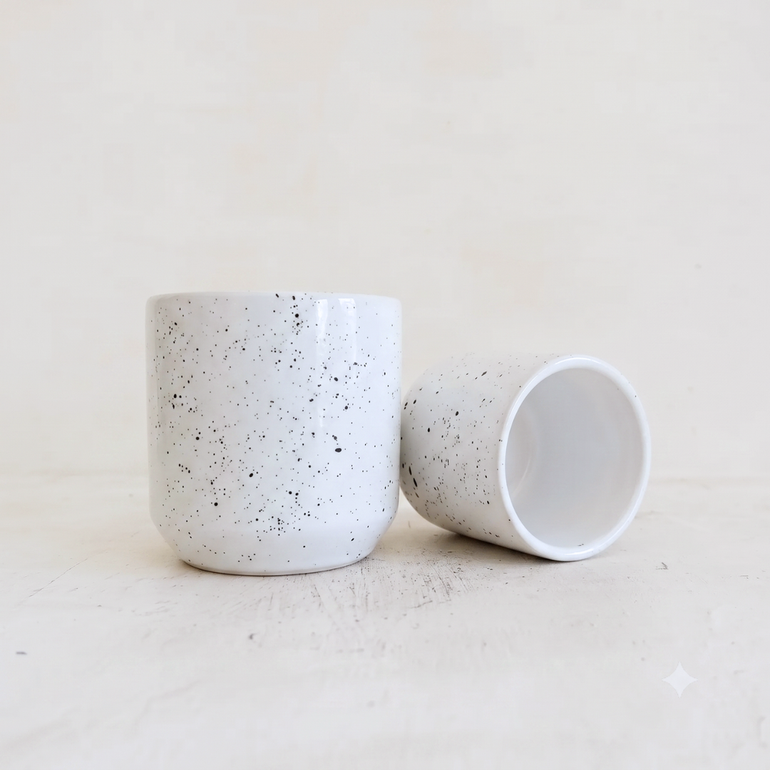 white speckled ceramic cup on white background