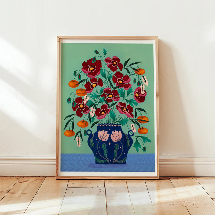 Framed Fine art print of a bright red floral display in a deep blue vase with light pink floral motif.