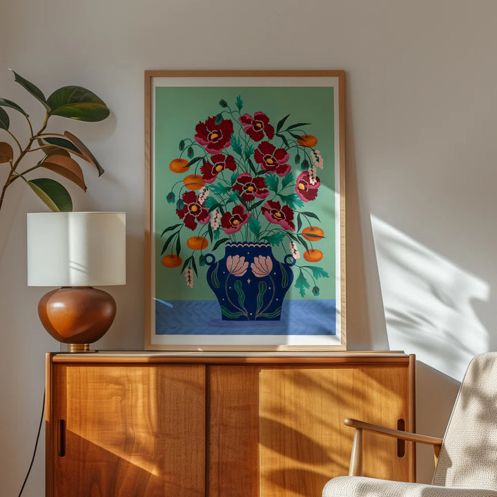 Framed Fine art print of a bright red floral display in a deep blue vase with light pink floral motif.
